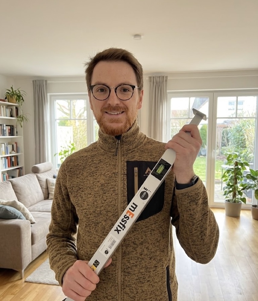 Daniel Schneeberger beim Aufmaß in einem Wohnzimmer